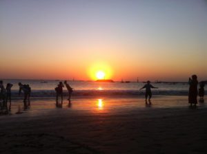 Stunning sunset view over the ocean in Bali with vibrant orange and golden skies reflecting on the water.